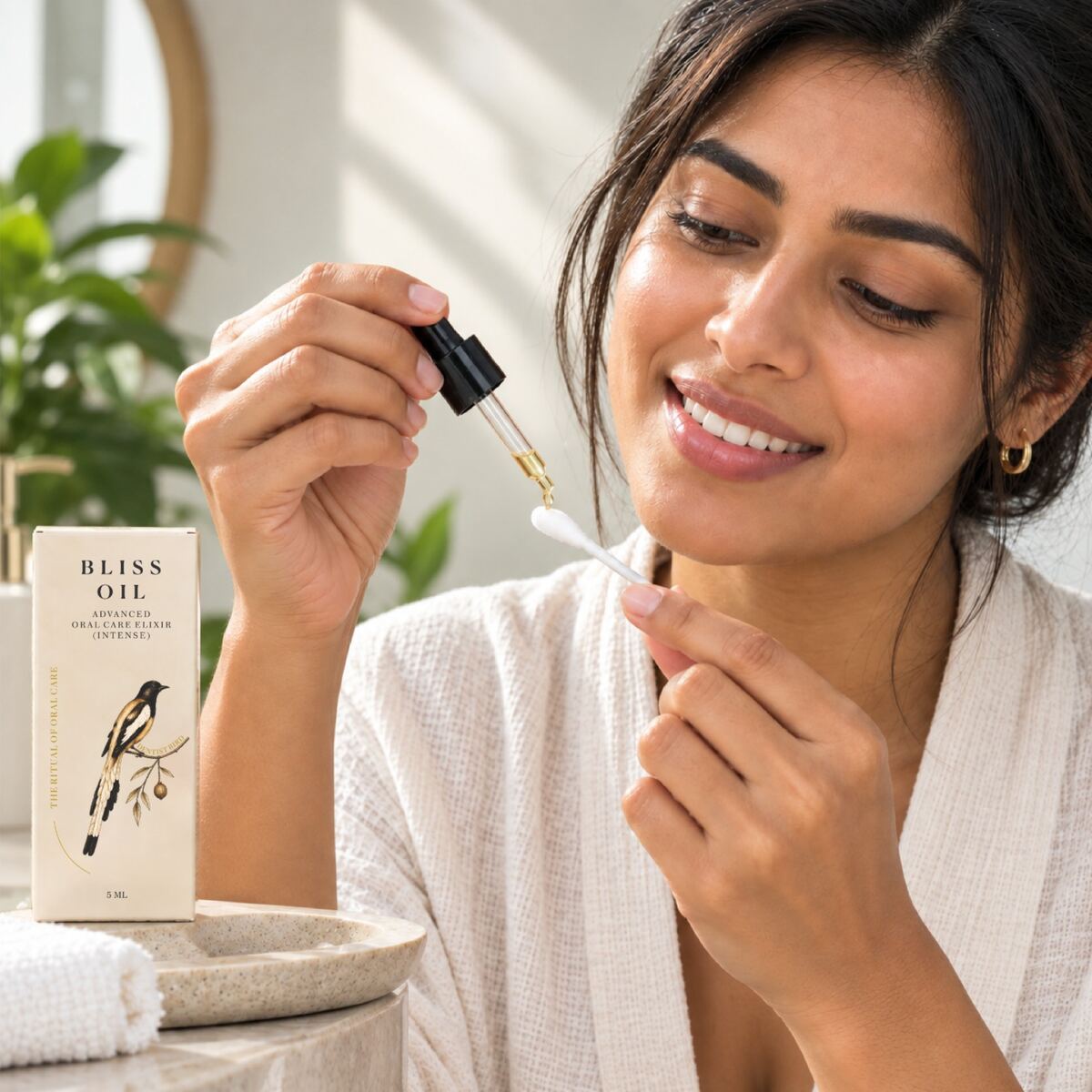 A woman smiling while applying Betru Bliss Oil with a cotton swab